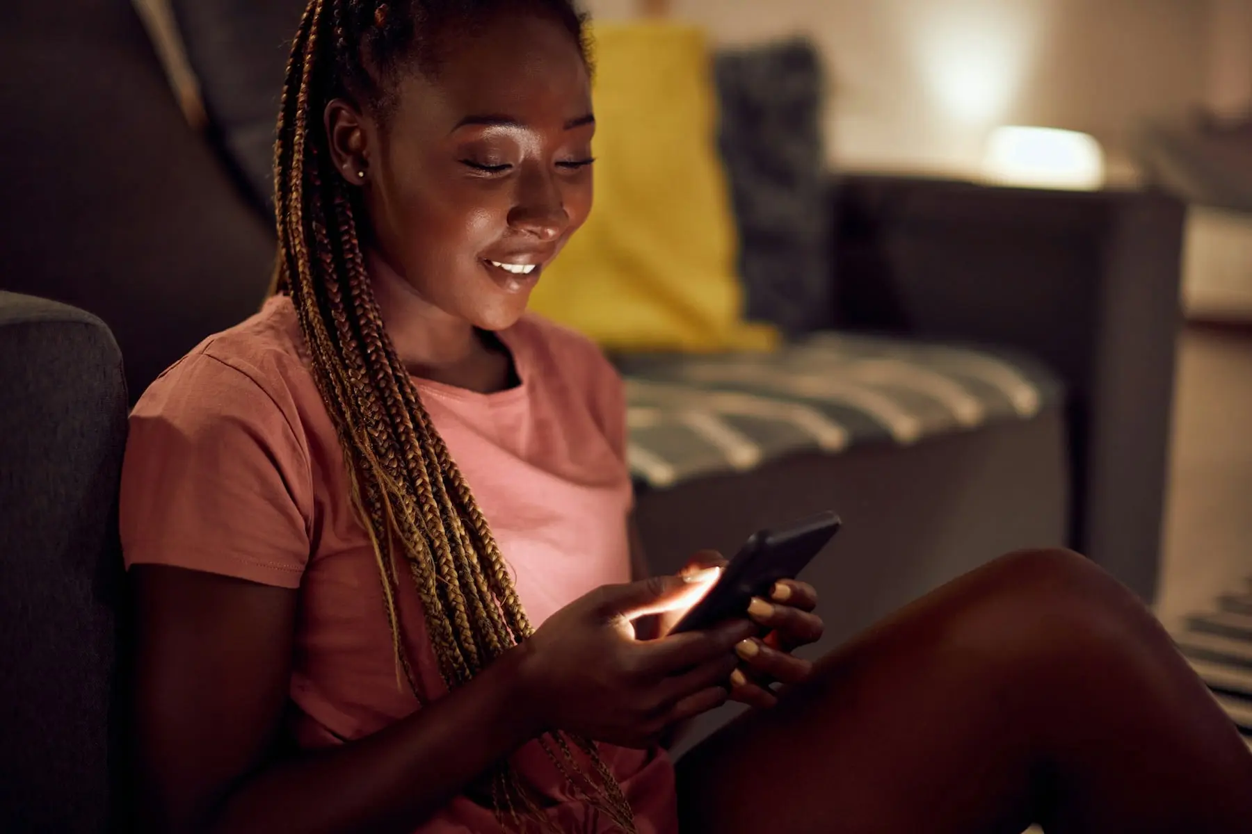 Homeowner smiling at her phone on the sofa